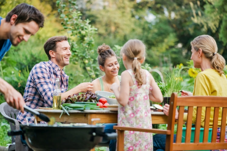 Famille autour d'un barbecue au jardin