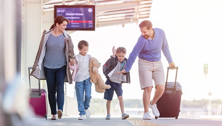 Famille heureuse avec ses valises à la gare